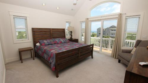 - une chambre avec un lit et un balcon dans l'établissement S2, Good Winds- Semi-Oceanfront, 6 BRs, Priv Pool, Close to Beach, Rec Rm, à Corolla