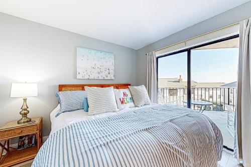 1 dormitorio con cama y ventana grande en Sea Sisters en Wrightsville Beach