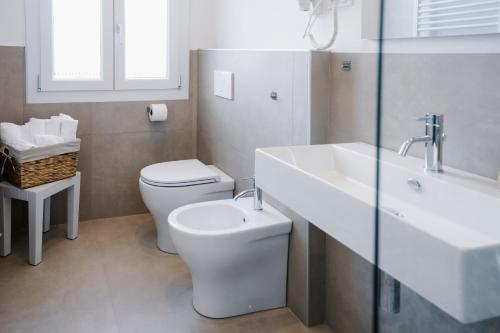 a white bathroom with a toilet and a sink at LaMì Room & Apartment in Castel San Pietro Terme