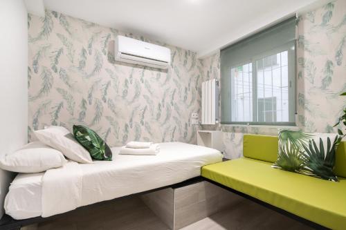 a room with a bed and a green bench at ALCALA QUINTANA - 3 Bedrooms in Madrid