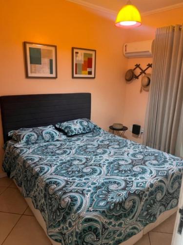 um quarto com uma cama com um edredom azul em É na beira do mar...com estacionamento exclusivo em Arraial do Cabo