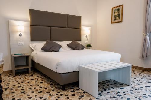 um quarto com uma cama grande e um banco ao lado em LaMì Room & Apartment em Castel San Pietro Terme
