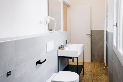 a bathroom with a white toilet and a sink at LaMì Room & Apartment in Castel San Pietro Terme