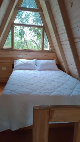 Bett in einem Zimmer mit einem großen Fenster in der Unterkunft Finca La Rivera in San Agustín