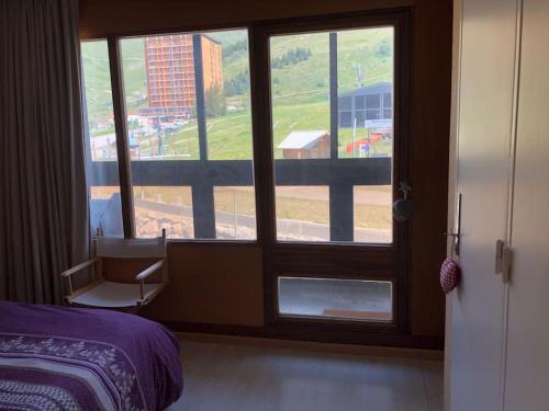 - une chambre avec une fenêtre donnant sur un bâtiment dans l'établissement Appartement traversant 4 pers pied des pistes vue imprenable, à Orcières