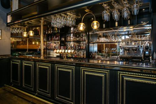 a bar with lots of glasses on the wall at Quality Hotel Statt in Hudiksvall