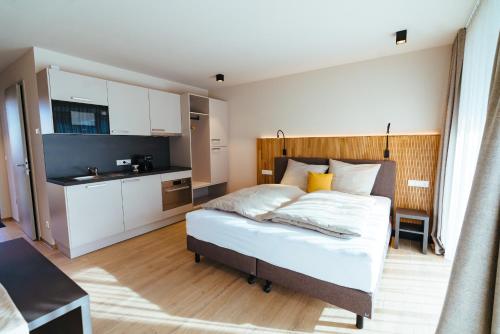 a bedroom with a bed and a small kitchen at Biohof Döbler Ferienwohnungen in Brackenheim