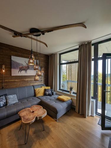 a living room with a couch and a table at Zadov - Apartmán Srdce Šumavy in Stachy