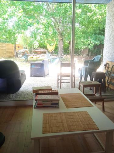 - un salon avec une table basse et une grande fenêtre dans l'établissement Maison avec jardin - 7 pers, à Carcans