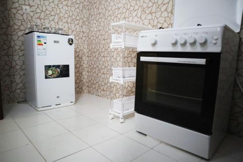 a kitchen with a stove and a refrigerator at Chez Mamanta in Saint-Louis
