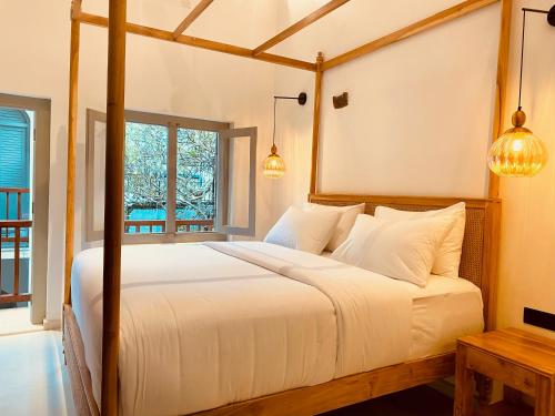 sypialnia z dużym łóżkiem z białą pościelą w obiekcie Ivy Lane Galle Fort w mieście Galle