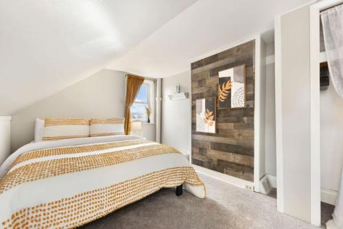a bedroom with a bed and a wooden wall at HostWise Stays - The Geneva - Easy Walk to Childrens in Pittsburgh