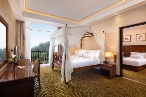 a hotel room with two beds and a balcony at The Golden Ridge Hotel in Nuwara Eliya