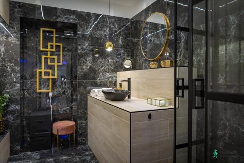 W łazience znajduje się umywalka i lustro. w obiekcie Apartament w Rynku II, MyWeek w mieście Radków