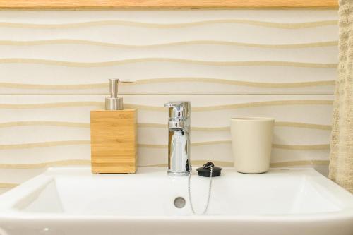 un lavabo de salle de bain avec un robinet et un distributeur de savon dans l'établissement White Volcano pool, gym and activities in Sport Center Fariones included, à Puerto del Carmen