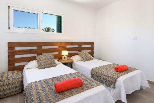 une chambre avec deux lits, une chaise et deux fenêtres dans l'établissement Green Volcano- pool, gym and activities in Sport Center Fariones included, à Puerto del Carmen