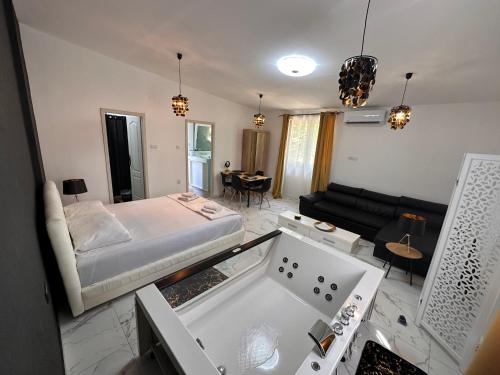 a large living room with a bed and a couch at Apartman sa jakuzijem in Palić