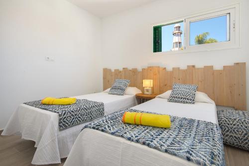 3 lits dans une chambre avec un phare en arrière-plan dans l'établissement Orange Volcano - pool, gym and activities in Sport Center Fariones included, à Puerto del Carmen