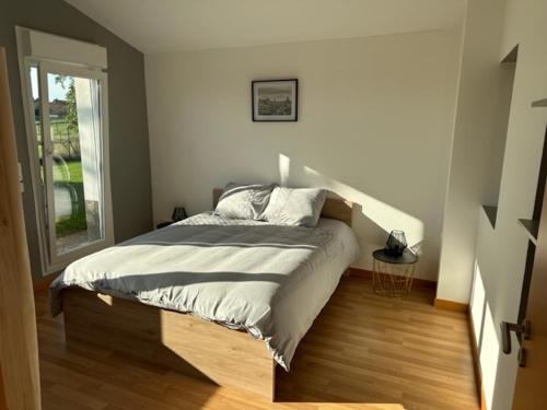 a bedroom with a bed in a room with a window at Le Nid Du Moulin in Batzendorf