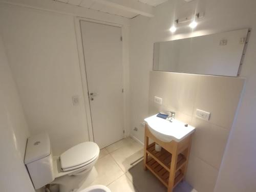 a white bathroom with a toilet and a sink at Casa nueva en Bariloche a orillas del Nahuel Huapi in San Carlos de Bariloche