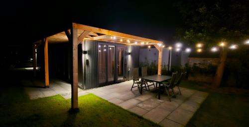 a gazebo with a table and chairs at night at Luxe Natuurhuis Veluwe Home 'De Bosvogel' in Ermelo