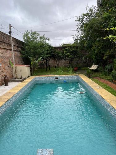 a swimming pool with two people in the water at Casa con piscina y parque in Garupá