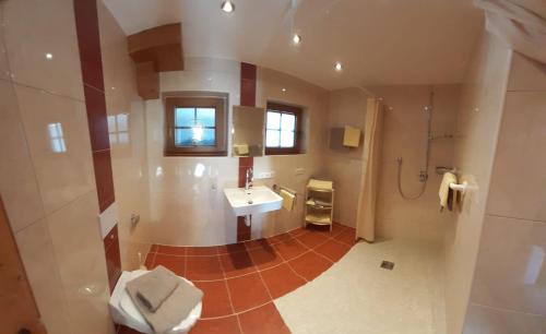 ein großes Bad mit einem Waschbecken und einer Dusche in der Unterkunft Ferienwohnung Haus Bergfrieden in Gerlosberg