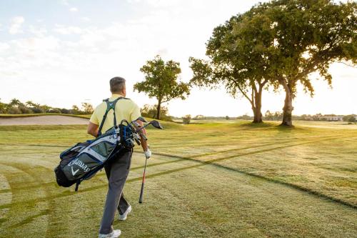a man with a bag walking on a golf course at Miccosukee Casino & Resort in Miami