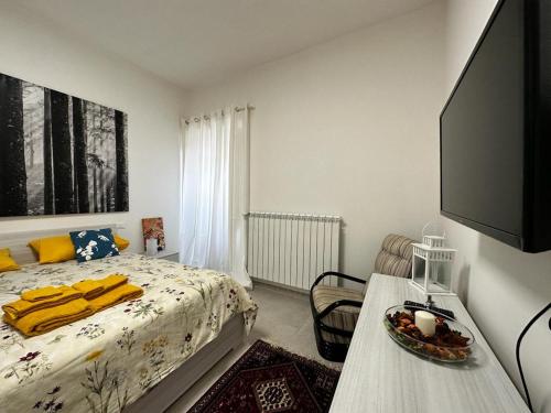 1 dormitorio con 1 cama y TV de pantalla plana en Il Nido di Domi, en LʼAquila