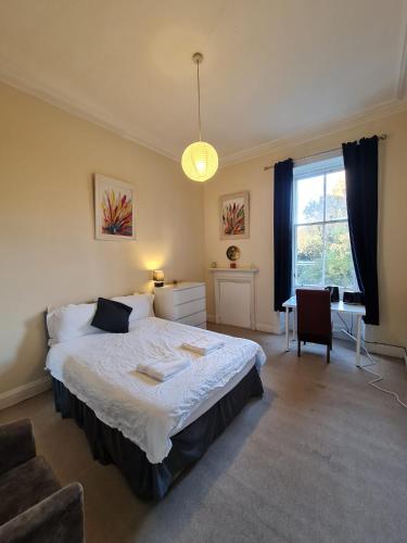 a bedroom with a bed and a chair and a window at Haymarket Station Rooms in Edinburgh