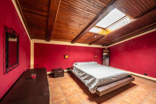 ein Schlafzimmer mit roten Wänden und einem großen Bett in der Unterkunft L'Oasi di Ramona in Polesine Parmense