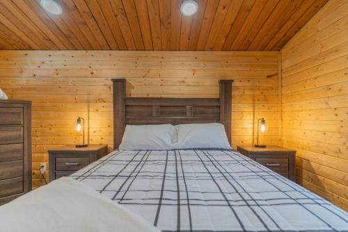 a bed in a wooden room with two night stands at The Alaskan Dream Lodge in Fairbanks