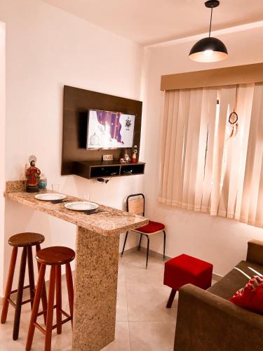 サン・トメー・ダス・レトラスにあるKitnet STL. Centroのリビングルーム(壁にテレビのあるバー付)