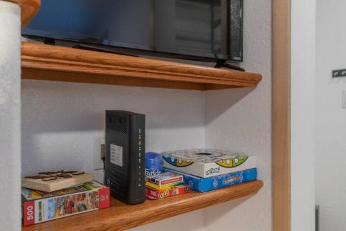 a book shelf with a tv and some books at The Little Airport Getaway in Fairbanks