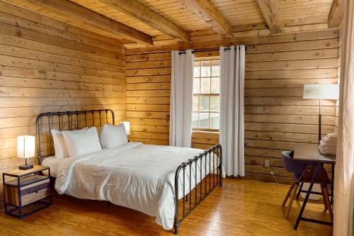 1 dormitorio con 1 cama en una pared de madera en Modern Log Cabin with Vineyard Views, en Penn Yan