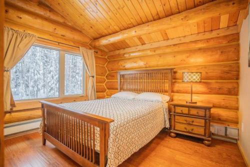 1 dormitorio con 1 cama en una cabaña de madera en Tucked Away Timber Upper Suite, en Fairbanks