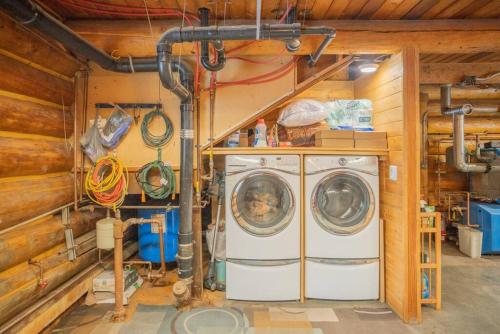a washer and dryer in a room with wooden walls at Tucked Away Timber Upper Suite in Fairbanks