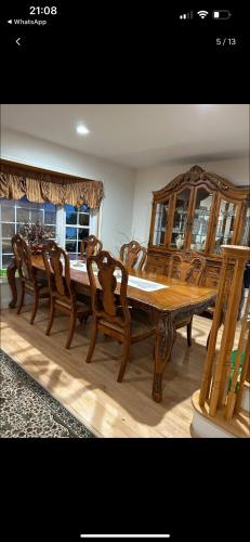 a wooden dining table and chairs in a room at Cozy greenery view among comfort in Haledon