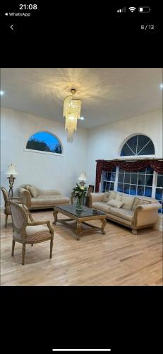 un salon avec des canapés et un lustre dans l'établissement Cozy greenery view among comfort, à Haledon