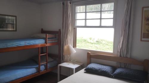 a bedroom with two bunk beds and a window at Lindo Sitio Junto à Natureza in Ibiúna