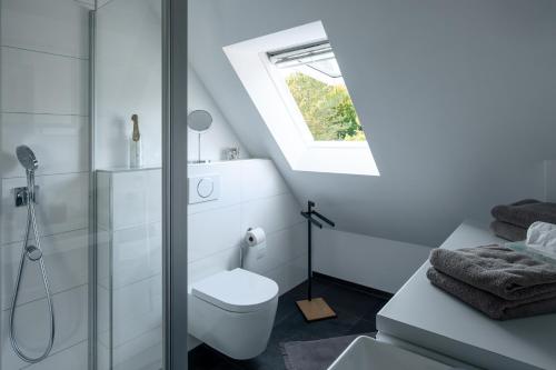 a white bathroom with a toilet and a window at DESIGN-Studio CHURCH 46 in Mülheim an der Ruhr