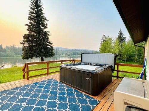 a hot tub on a deck with a view of a lake at Life is Better on the River in Fairbanks