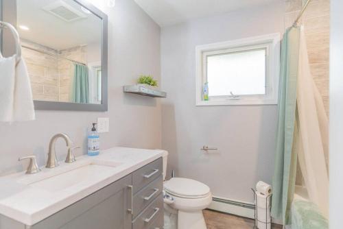 a bathroom with a sink and a toilet and a window at Life is Better on the River in Fairbanks