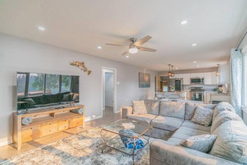 a living room with a couch and a ceiling fan at Life is Better on the River in Fairbanks