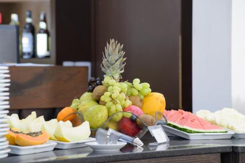 タウバテにあるFaro Hotel Taubatéのテーブルの上にはワインボトルと果物がいっぱい