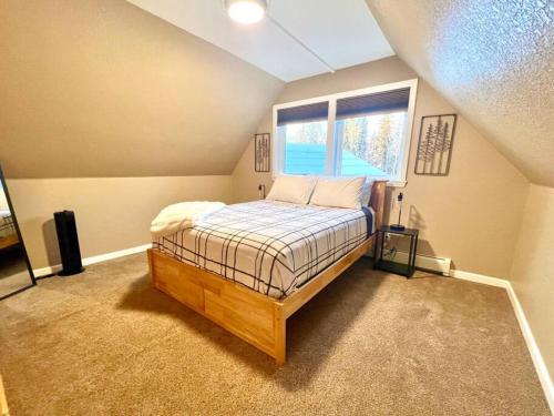 a bedroom with a bed in a room with a window at Northern Lights Layover in Fairbanks