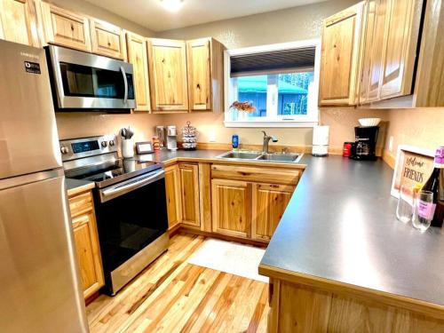 eine Küche mit Holzschränken und Küchengeräten aus Edelstahl in der Unterkunft Northern Lights Layover in Fairbanks
