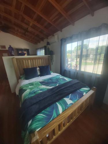 a bedroom with a wooden bed with a window at Bella Vita Casitas in Placencia Village