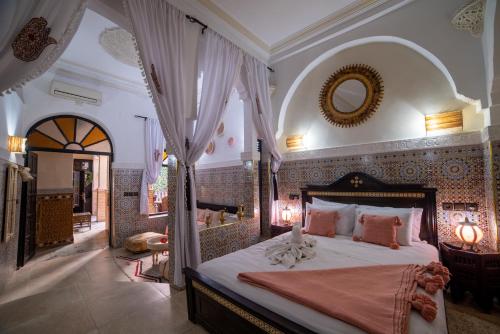 a bedroom with a large bed with a canopy at Riad Arabesque in Marrakesh
