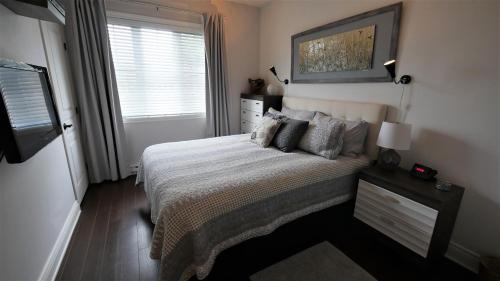 a small bedroom with a bed and a window at Le 204 Champlain Bromont in Bromont